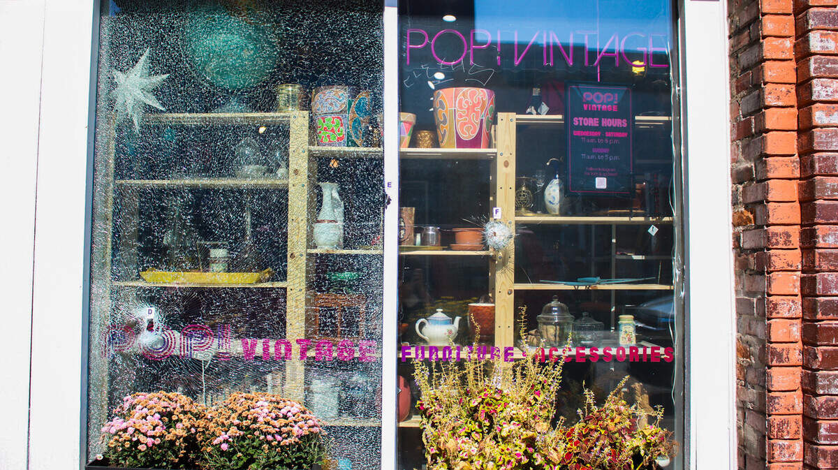 The glass windows at Pop! Vintage Furniture and Accessories on Westport Road were shattered when gunfire erupted around 8 p.m. Wednesday. Four men and a juvenile was injured in the gunfire, police said.