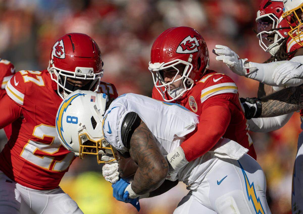 Kansas City Chiefs linebacker Drue Tranquill (23) tackles Los Angeles Chargers running back Omarion Hampton (8) during the first half on Sunday, Dec. 14, 2025 at GEHA Field at Arrowhead Stadium in Kansas City.