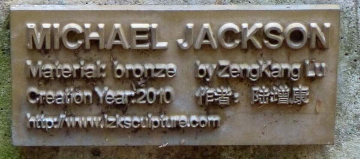 The plaque on the sculpture.