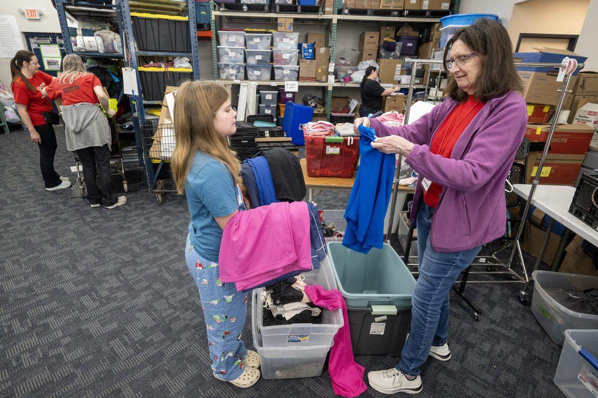 Volunteer Madison Just, 10, helps sort clothes alongside her grandmother, Jeanne Meadows, a volunteer at the Starfish Project-a nonprofit that provides essential items free of charge to those in need-on Thursday, Feb. 12, 2026, in Olathe. The organization has recently been notified that it must relocate.