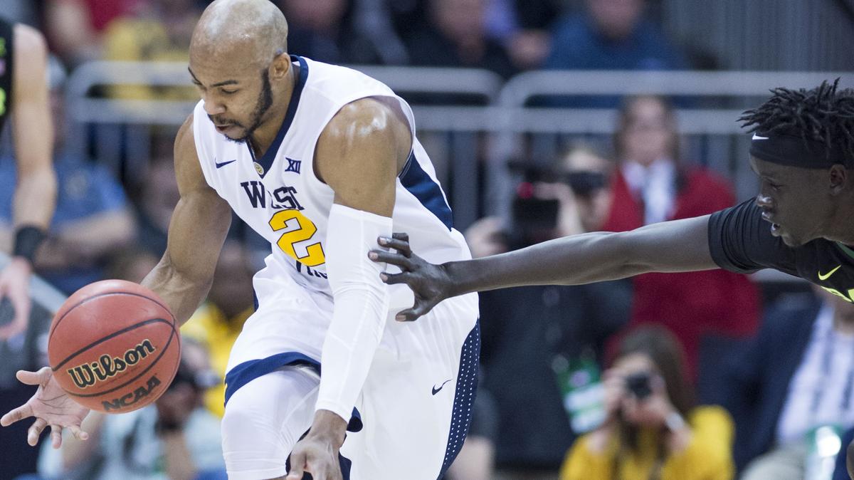 West Virginia Mountaineers guard Jevon Carter (2) grabbed a loose ball as Baylor Bears forward Nuni Omot (21) reached out after dribbling off of his foot in the first half of the West Virginia Univeristy and Baylor University quarterfinal round of the Big 12 Tournament at the Sprint Center on Thursday, March 8, 2018, in Kansas City, Missouri.