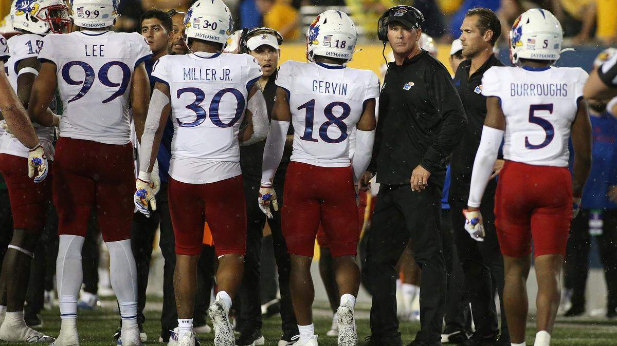 Kansas football coach Lance Leipold, third from right, meets with his players during a break in the second half of last weekend’s game against West Virginia in Morgantown, W.Va.