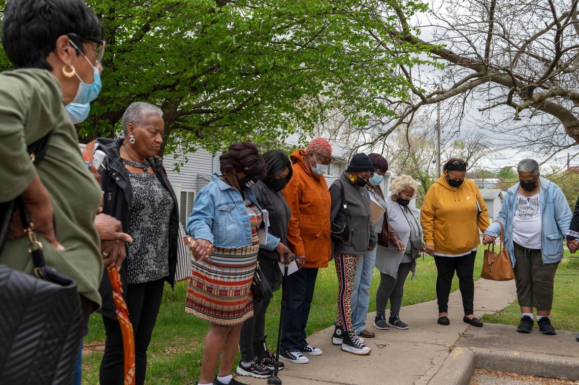 Residents of Parade Park Homes join in a prayer outside the Park Parade Homes community meeting room in Kansas City on April 30, 2022. The prayer session followed a meeting where residents heard from members of the housing cooperative board about efforts underway aimed at saving Parade Park from foreclosure.
