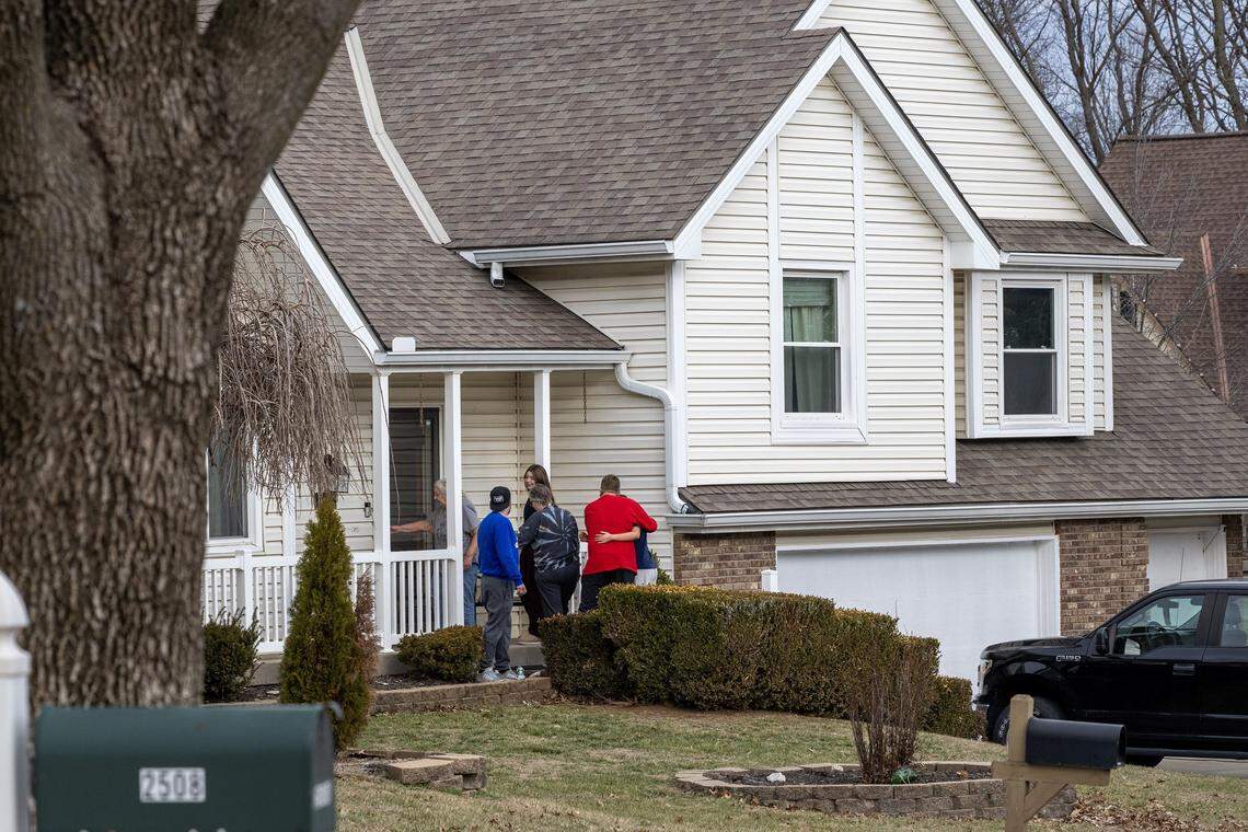 People embrace outside a residence near NE 78th Street on Tuesday, Jan. 13, 2026, in Kansas City, following Monday's neighborhood shooting.