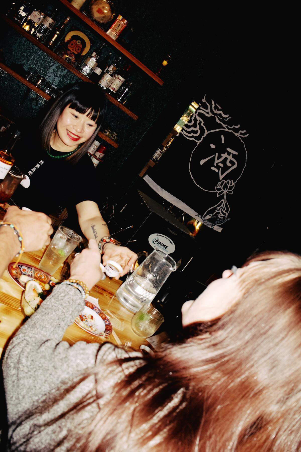 Moon Bar co-owner Saranya Hubbard serves guests during the bar’s opening night. The concept emphasizes hospitality and draws inspiration from flavors and traditions found across Asia.
