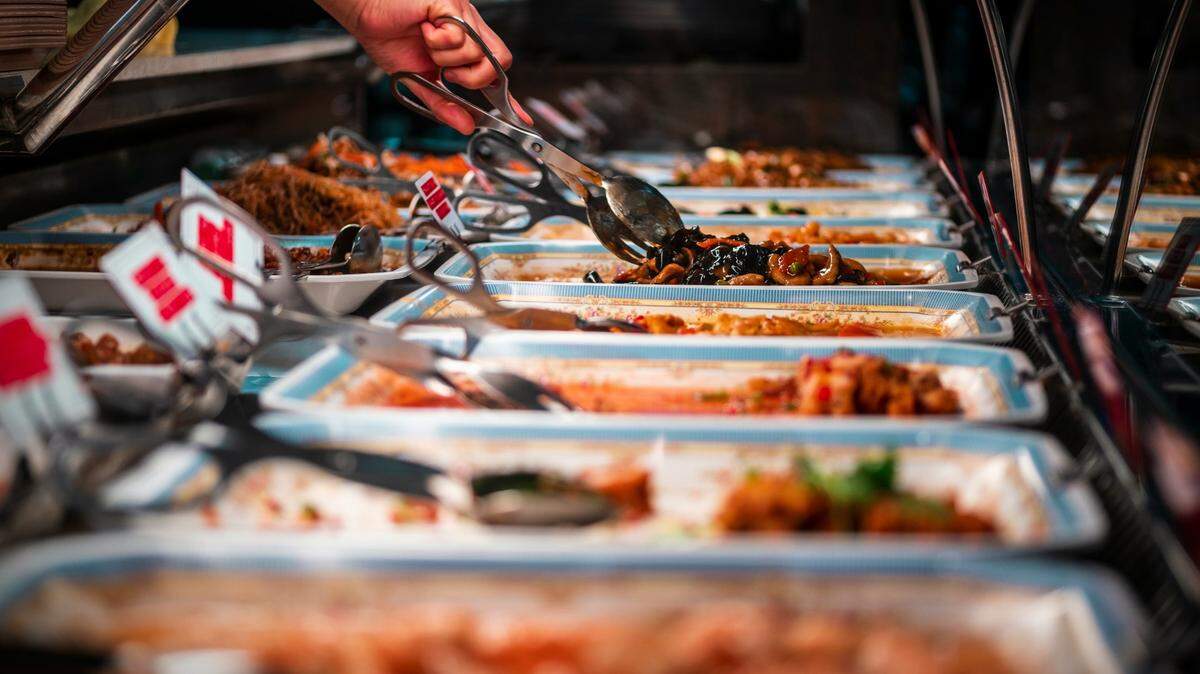 In this stock photo, a diner dishes out food from a buffet. Some Kansas City-area restaurants received low scores on their health inspections.