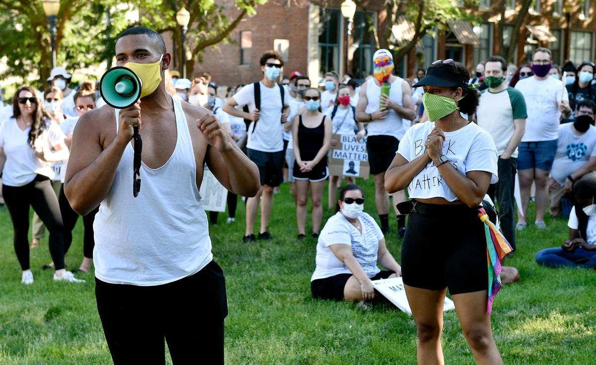 Justice Horn, with the local chapter of Black Lives Matter, left, speaks to protesters as Sam Wells, right, who helped organize the march, listens. Several hundred protesters went on a silent march against police brutality, racism and the killing of George Floyd and others beginning at the River Market Sunday, June 7, 2020. Many wore white, so the names of those killed can be written on them.