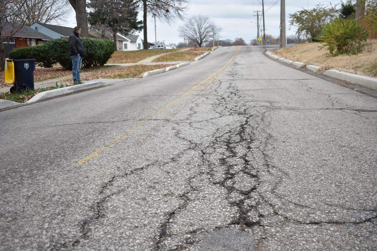 Waldo resident Frank Sereno, top left, observes cracked pavement along 89th Street near Wornall Road on Thursday, Nov. 30, 2023 in Kansas City.