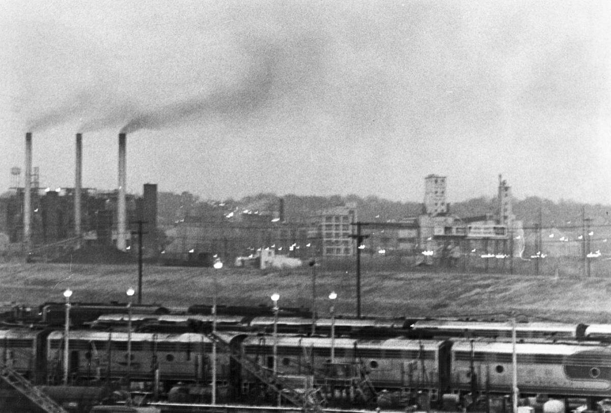 This was the scene in December of 1965 looking northeast from the railroad yards in the Argentine district of Kansas City, Kansas, and across the Kansas River to industrial structures in the Armourdale district. Smokestacks belched pollutants into the air which was common for the times.