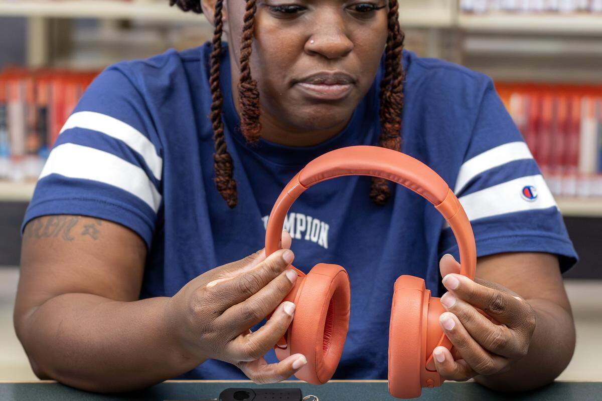 Danielle Benson holds a pair of headphones given to her by her eldest son, Aaron Williams, on Tuesday, Aug. 19, 2025, in Kansas City. Williams, 18, was killed outside an apartment complex on July 20. 