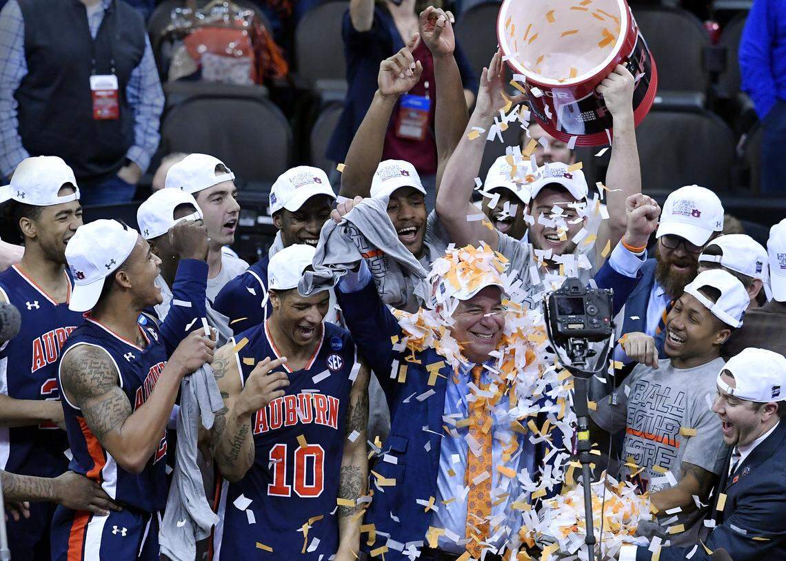 Auburn coach Bruce Pearl, covered in confetti, celebrated with his Tigers after they took down Kentucky 71-77 in overtime Sunday in the championship game of the NCAA Midwest Regional at the Sprint Center in Kansas City.
