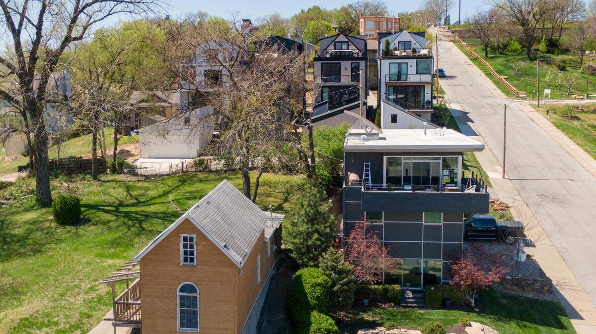 A home built in 1920, left, sits in start contrast to the contemporary homes which dot the streets on Kansas City’s historic West Side neighborhood, including these homes just off of West Pennway at Madison Avenue.