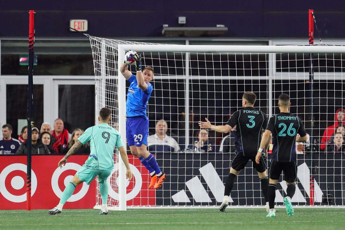 Sporting Kansas City goalkeeper Tim Melia leaps to save a shot against the New England Revolution.
