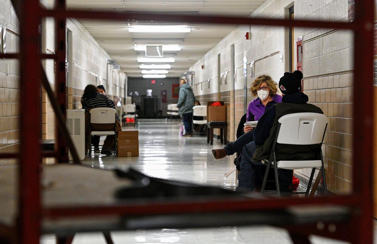 Along with other volunteers, Julie Brewer, executive director of United Community Services of Johnson County, asks survey questions of a man who sought shelter Tuesday, Jan. 25, 2022, a night when temperatures dropped into the low teens. Volunteers conducted an annual point-in-time survey of people experiencing homelessness at Project 1020 in Lenexa.