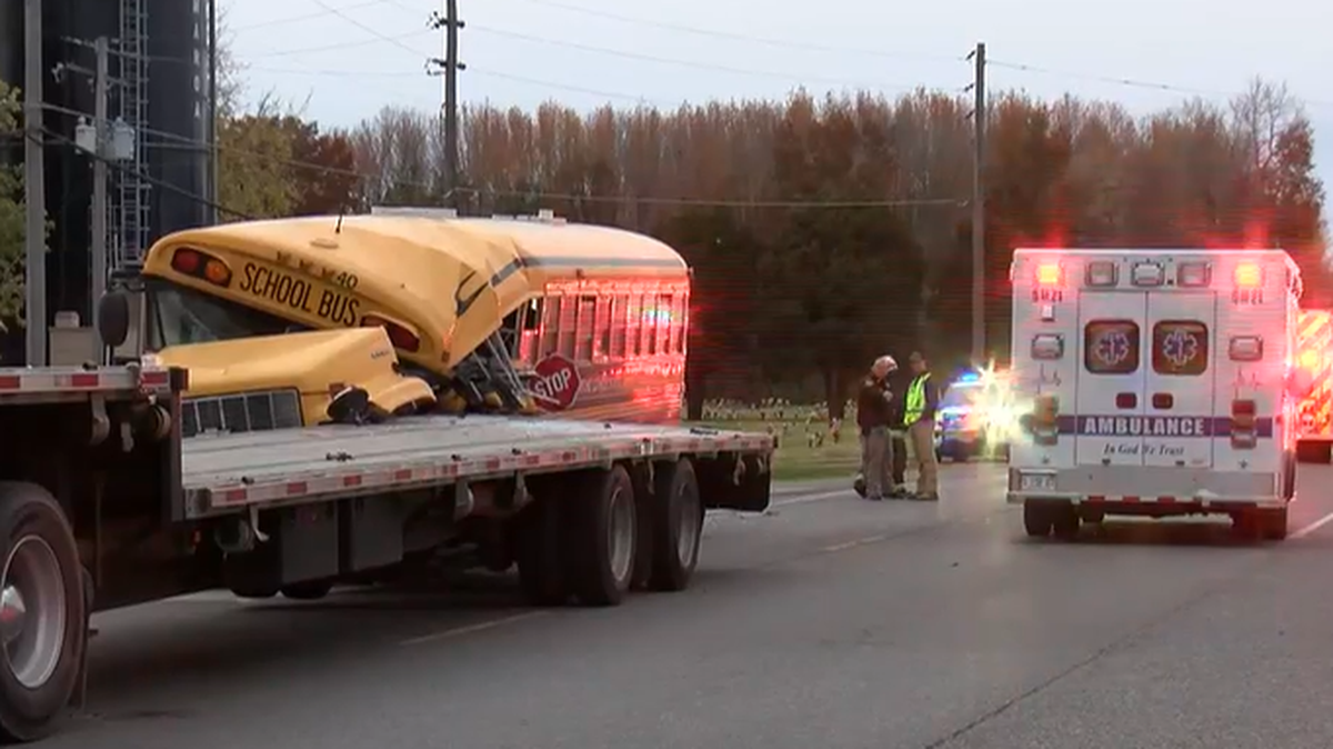 Four students and a school bus driver were injured when the bus crashed into a stopped trailer, police said.
