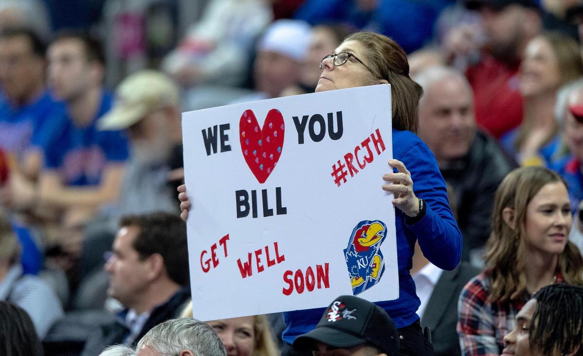 A Kansas fan holds up a sign with well wishes to Kansas head coach Bill Self during an NCAA college basketball game against West Virginia in the second round of the Big 12 Conference tournament Thursday, March 9, 2023, in Kansas City.