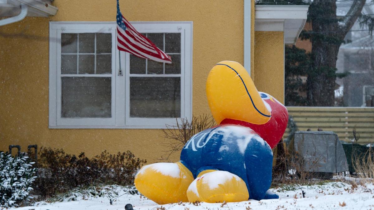 An inflatable KU Jayhawk yard decoration is weighed down by snow on Thursday, Dec. 22, 2022, in Kansas City.