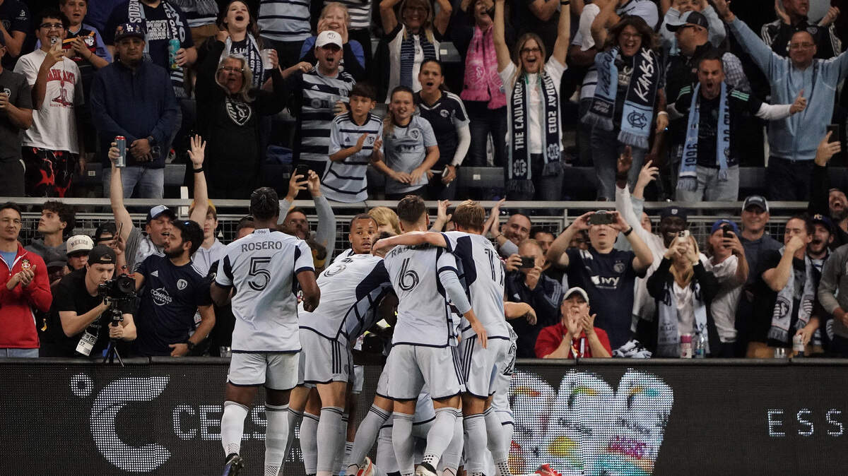 Sporting Kansas City forward Johnny Russell is mobbed by teammates after scoring the first of his two goals against Minnesota United FC during Saturday night’s MLS match at Children’s Mercy Park.