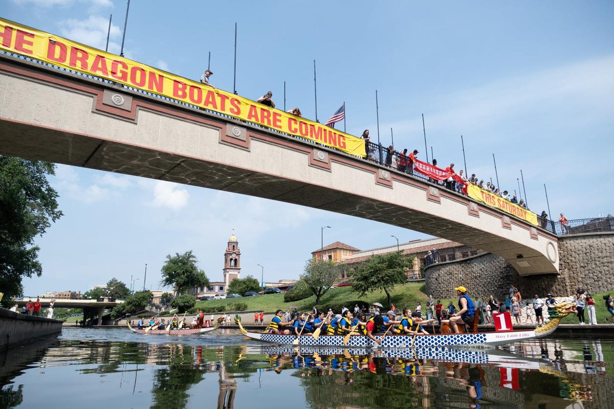 Dragon Boat race competitors paddle beneath Sister City Bridge Saturday on Brush Creek in Kansas City.