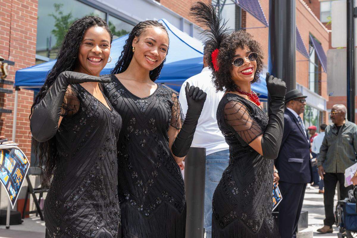 Women dressed as ‘flappers’ pose for photographs at the re-opening of the pedestrian mall in the 18th & Vine Jazz District on Wednesday, May 27, in Kansas City.