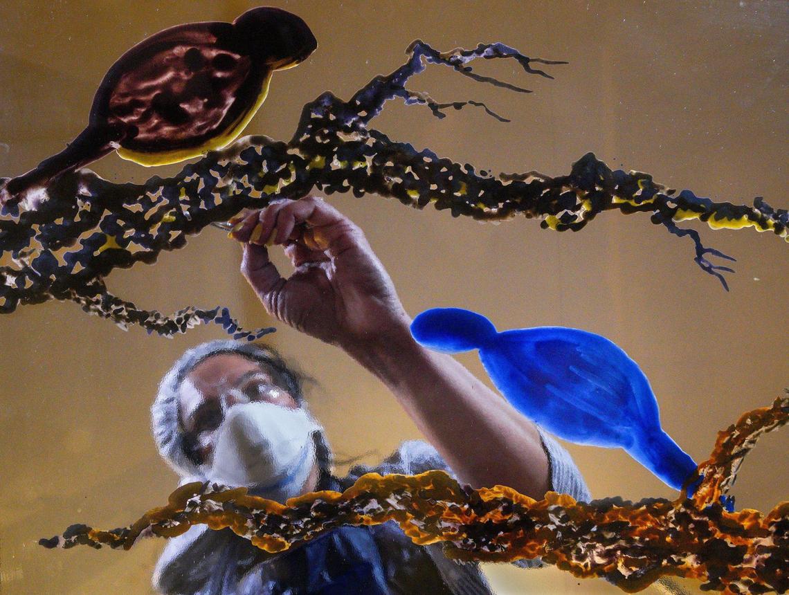 In her Overland Park home studio recently, Hasna Sal does color blocking on a section of a panel that will show the Kansas state bird, the western meadowlark, and the Missouri state bird, the Eastern bluebird.