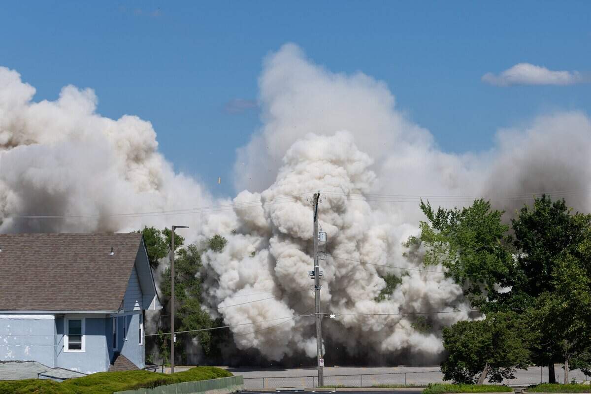 A cloud of smoke fills the air after the former Embassy Suites building, owned by Saint Lukes Hospital implodes on Sunday, July 12, 2026. Saint Luke's plans to use the lot for staff parking while reserving it for future campus development.