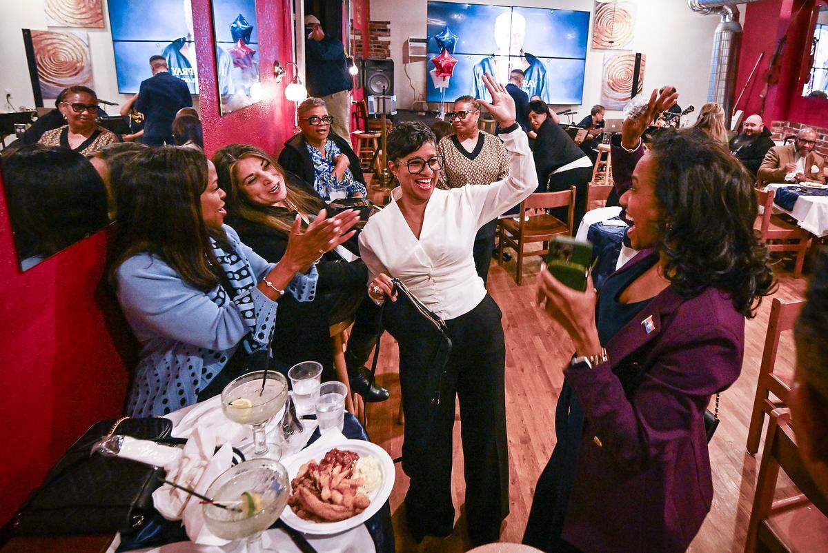 Wyandotte County UG CEO/mayor candidate Christal Watson, center, high fives Kansas City, Missouri, Mayor Pro Tem Ryana Parks-Shaw after seeing election results Tuesday at a watch party at John's Java and Jazz in Kansas City, Kansas.