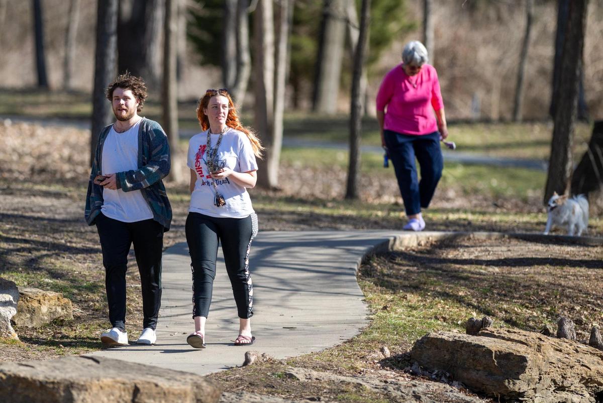 Kyle Berry and Sarah Motter of Shawnee walked along the path at Antioch Park enjoying the unseasonably warm weather before a cold front moved in Tuesday in Merriam.