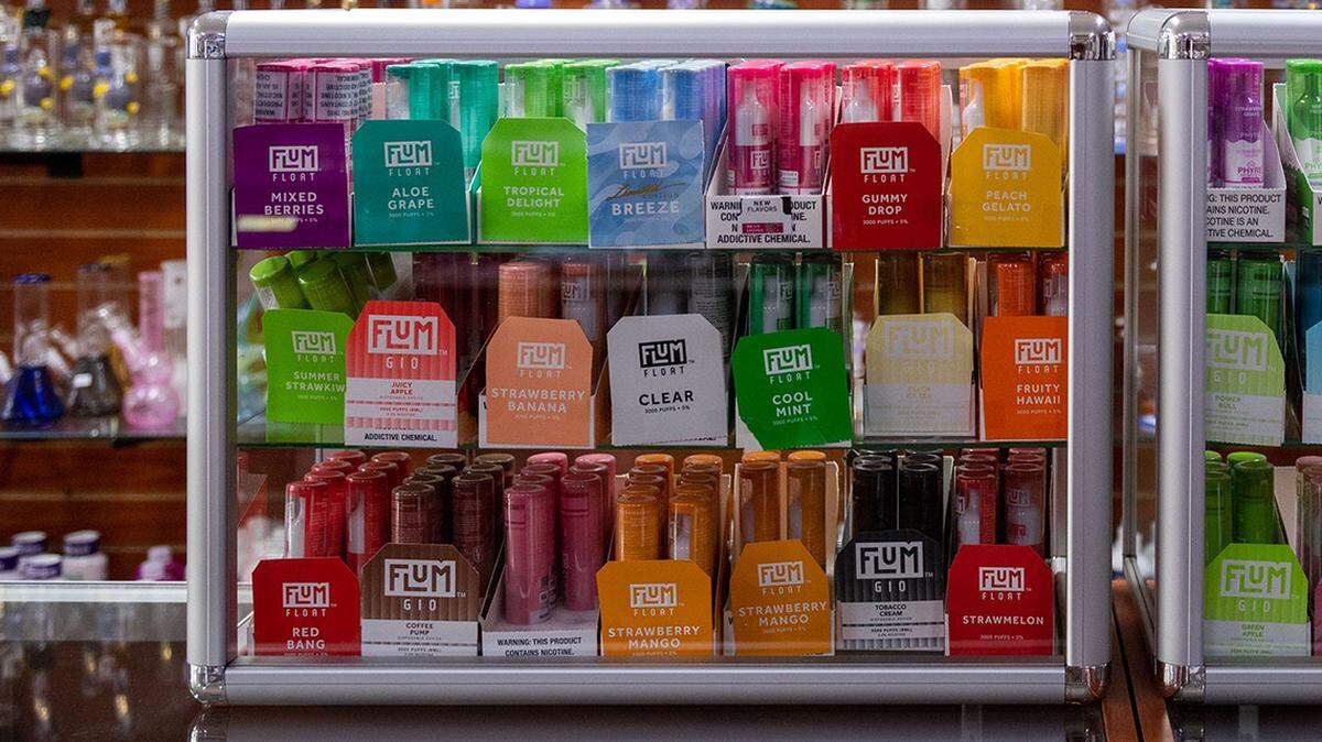 A variety of glass bongs rest on shelves behind a display of different flavored tobacco vapes inside Mike’s Smoke Shop in Castroville, Calif., on Wednesday, Jan. 19, 2022.