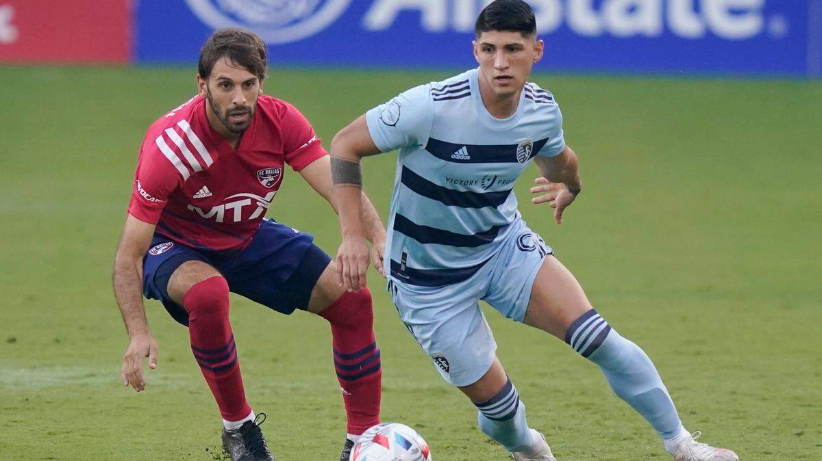 Sporting Kansas City forward Alan Pulido, right, takes control of the ball in front of FC Dallas midfielder Ryan Hollingshead, during the first half Saturday night in Frisco, Texas.