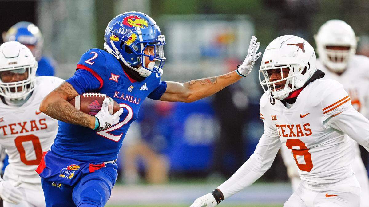 Kansas Jayhawks wide receiver Lawrence Arnold (2) stiff arms Texas Longhorns defensive back Terrance Brooks (8) during the second half at David Booth Kansas Memorial Stadium on Aug. 22, 2023.