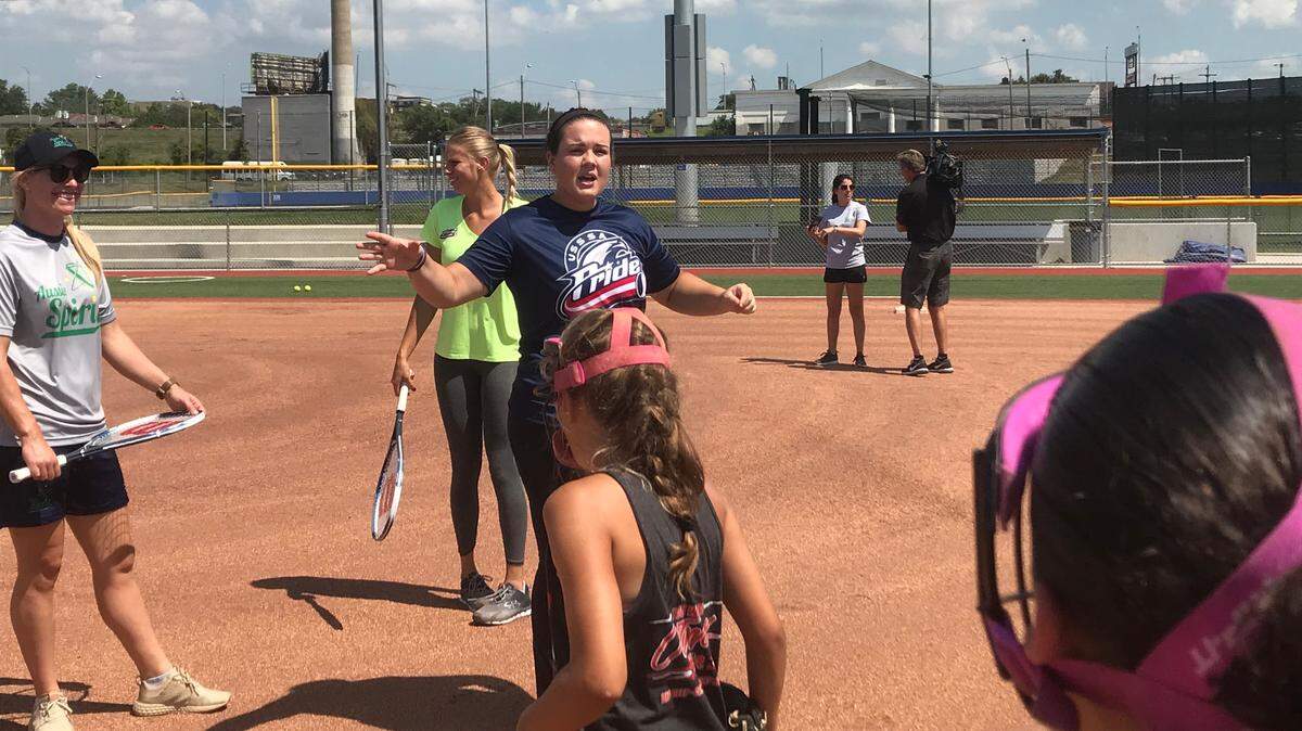 Truman High and OU grad Paige Parker, now a professional softball player with the USSSA Pride, instructs kids during a Kansas City Urban Youth Academy clinic on Tuesday.