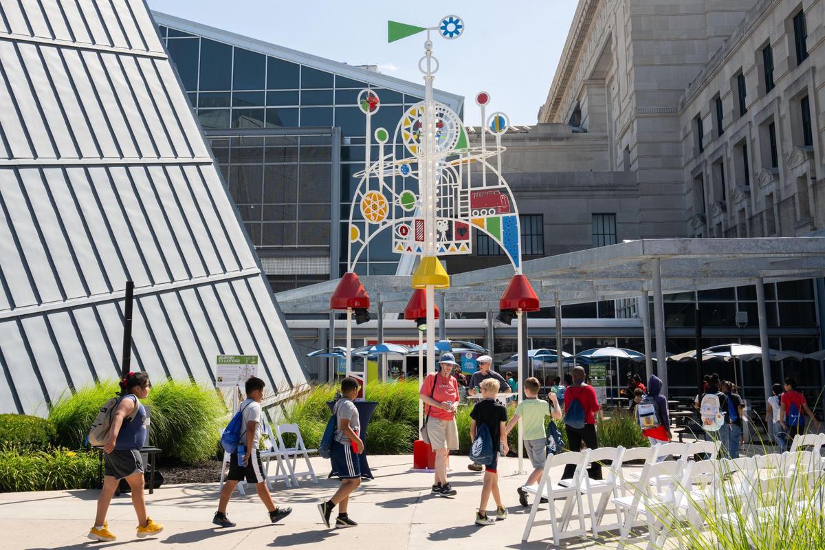 A group of summer school children walk past Union Station’s newest sculpture titled ‘Journey to Wonder,’ on Thursday, June 26, 2025. The sculpture is 28-feet tall and features kinetic elements and light and sound effects.