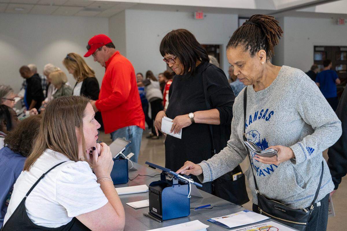 Election workers assisted Johnson County residents who arrived for the first day of in-person advance voting for the 2024 General Election at The Arts and Heritage Center on Oct. 19, 2024, in Overland Park.