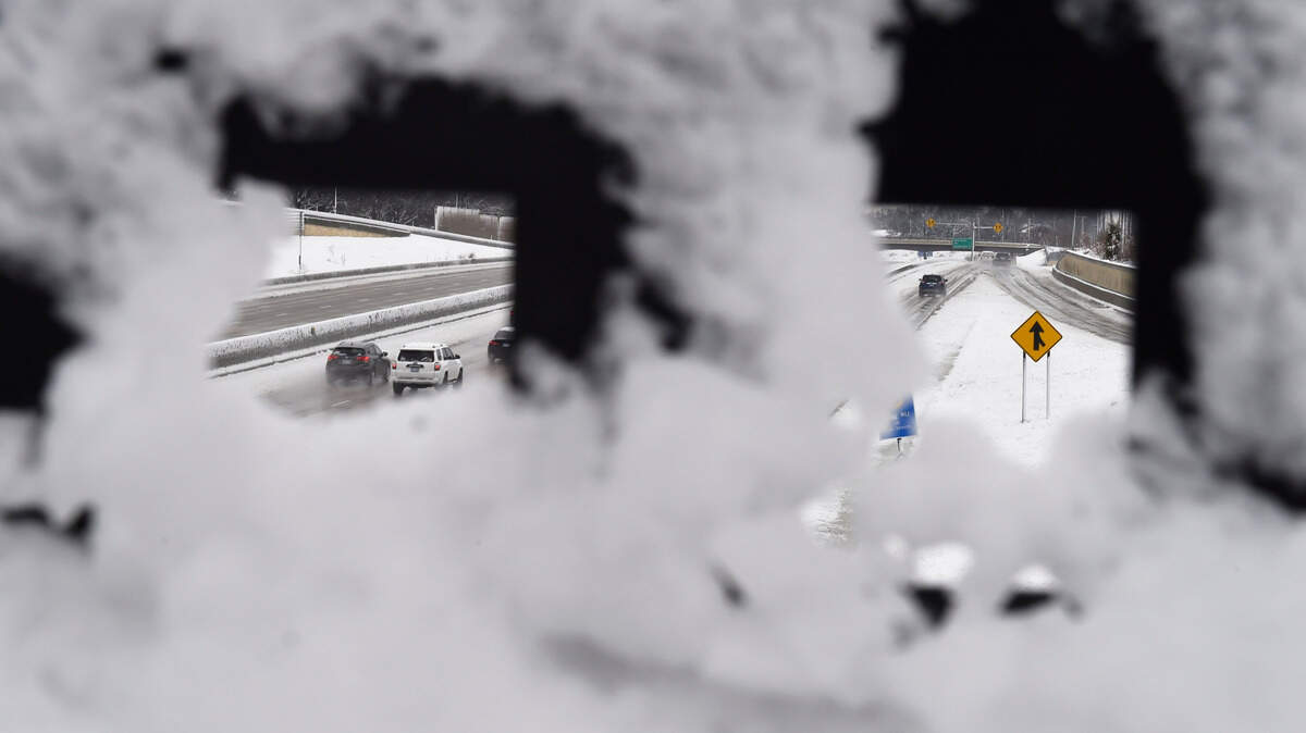 Snow is sticks to a bridge guard rail Thursday over U.S. 69 highway in Overland Park. Several inches of wet snow fell overnight greeting commuters with slick roads.