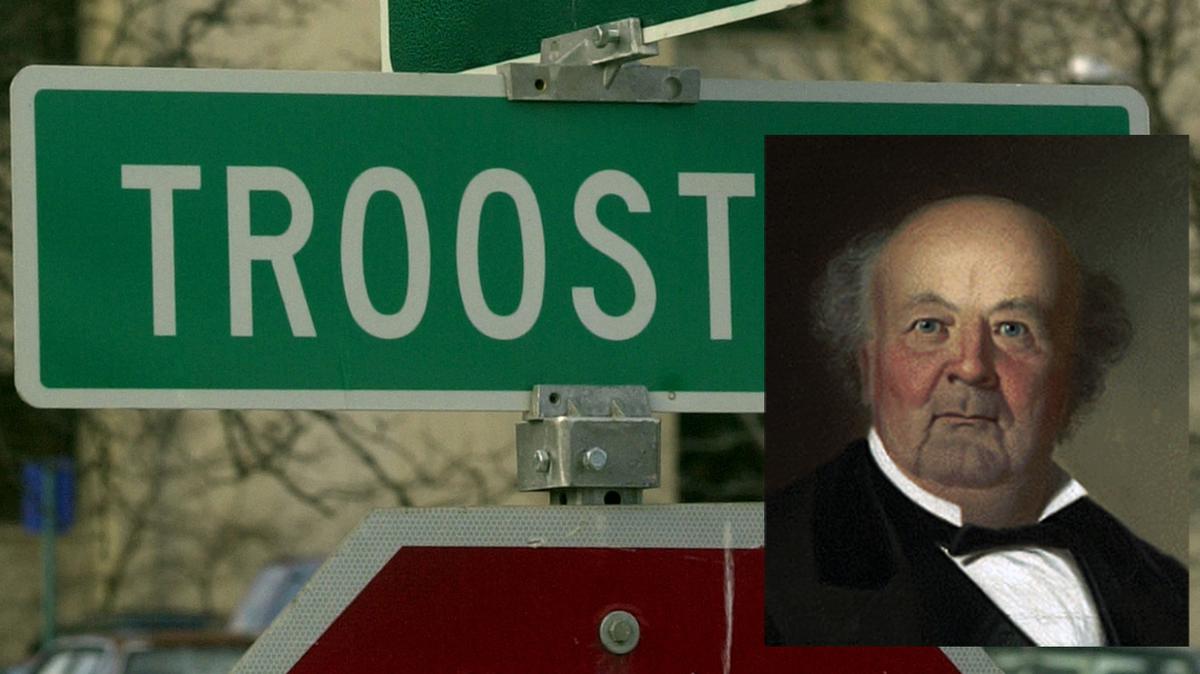 A Troost Avenue street sign overlaid with a mugshot of Benoist Troost, the slaveholder the street is named after