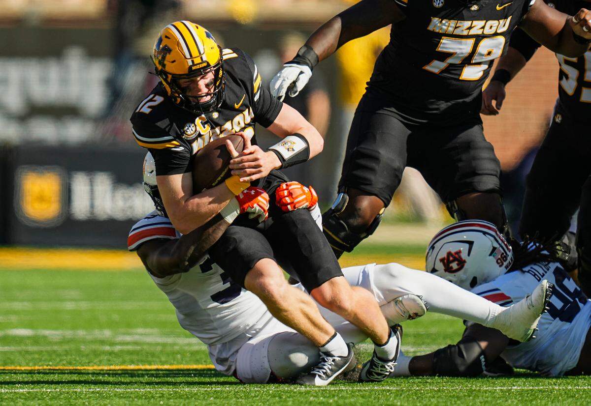 Missouri Tigers quarterback Brady Cook is brought down by Auburn Tigers nose tackle Jalen McLeod during Saturday’s game at Faurot Field at Memorial Stadium.