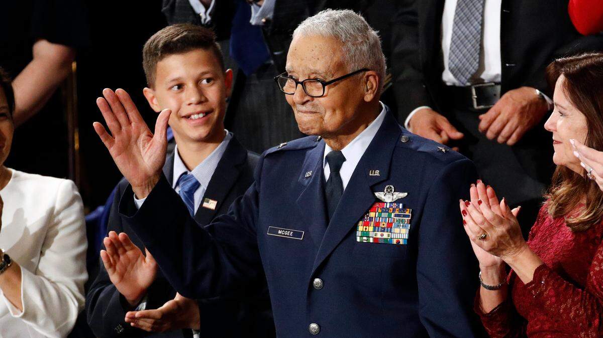 Tuskegee airman Charles McGee, 100, and his great grandson Iain Lanphier react as President Donald Trump delivers his State of the Union address to a joint session of Congress on Capitol Hill in Washington, Tuesday, Feb. 4, 2020. McGee died Sunday at age 102.