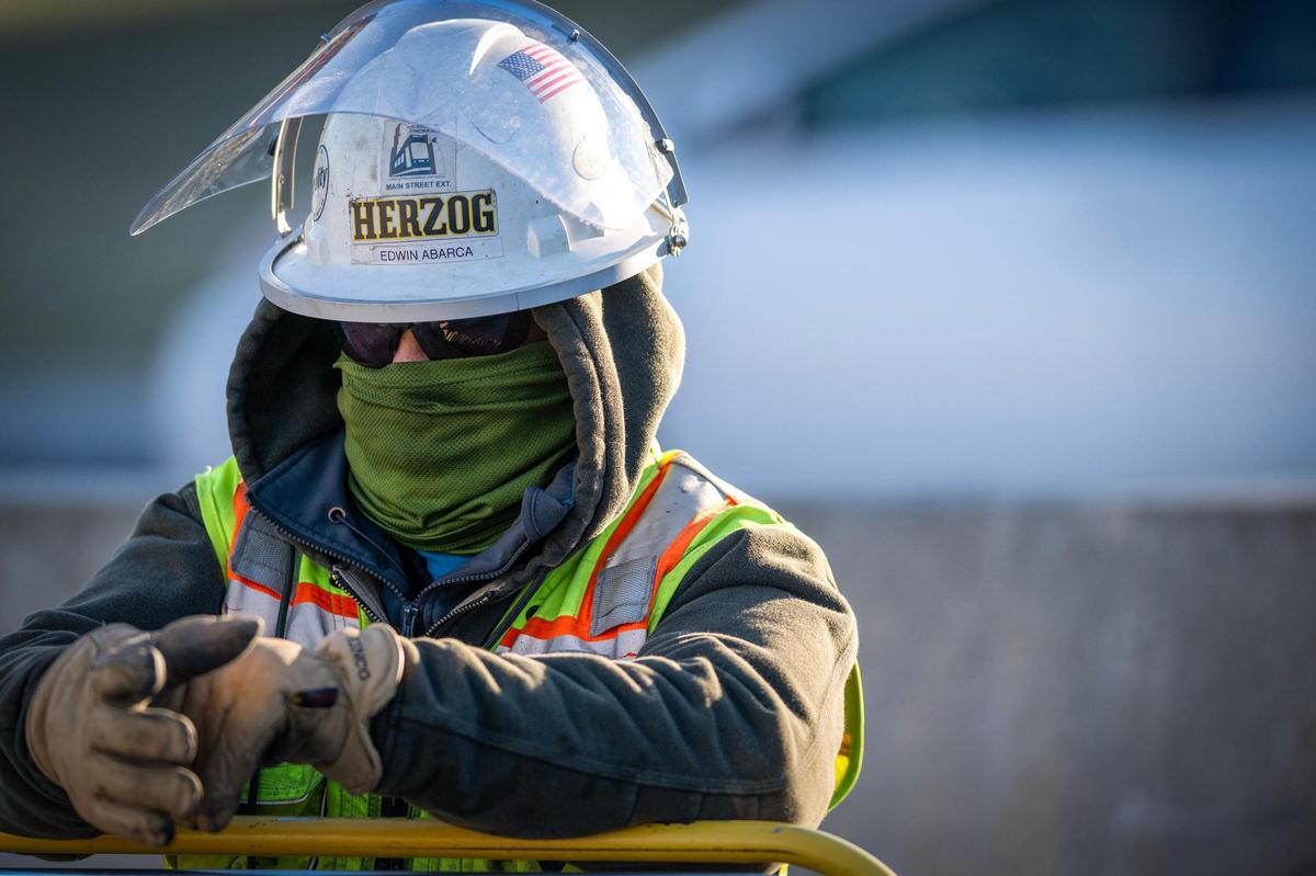 Construction worker Edwin Abarca was bundled against the bitter cold Wednesday as he worked on the KC Streetcar expansion along Main Street near Pershing Road in Kansas City.