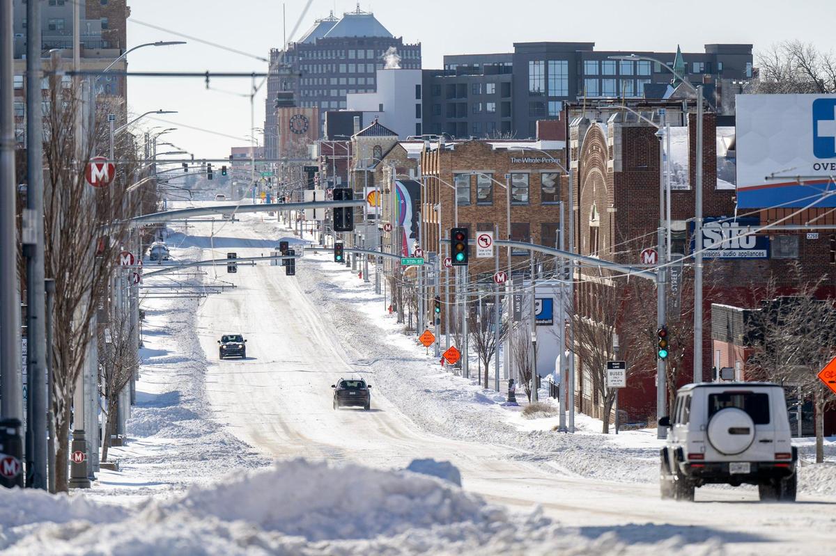 Snow blankets Main Street as drivers navigate the street on Monday, Jan. 6, 2025, in Kansas City.