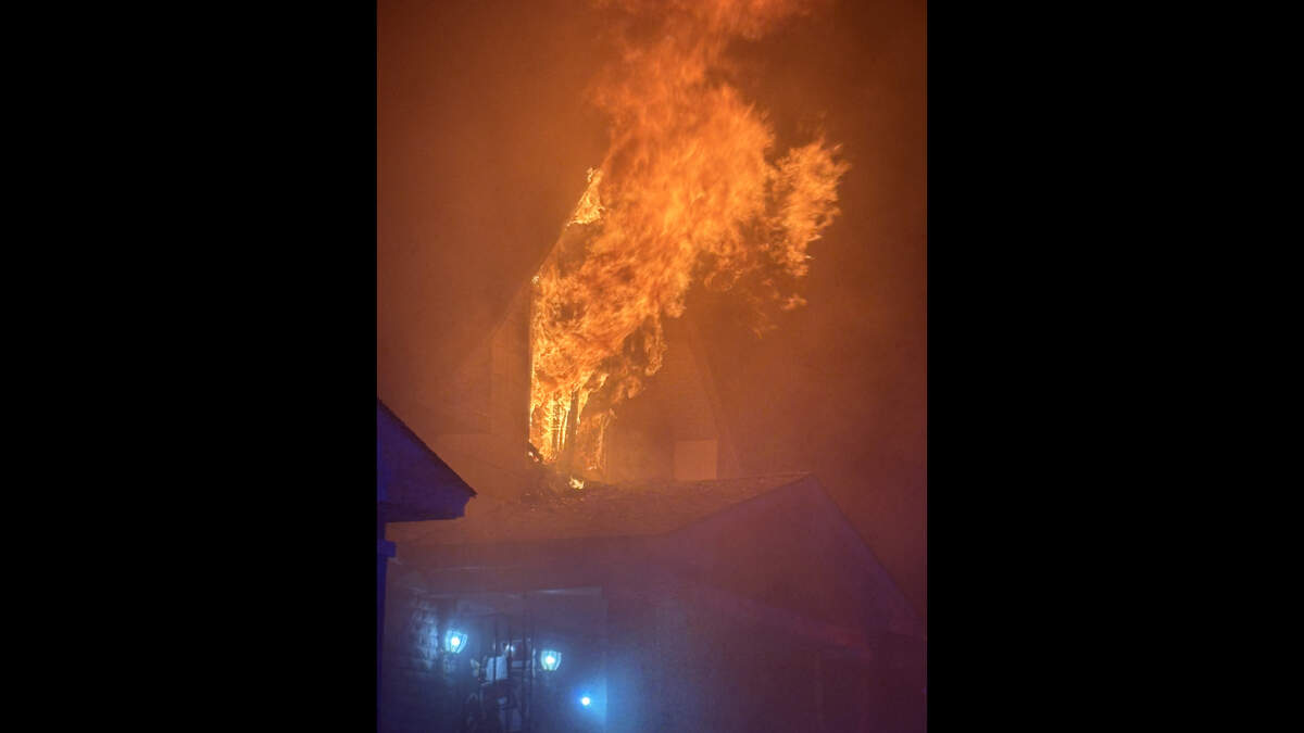 Flames shoot from a second-floor window of a home in the 1600 block of Elmwood Avenue. One person died in the fire and three adults were displaced in the fire early Tuesday, a Kansas City Fire Department spokesman said.