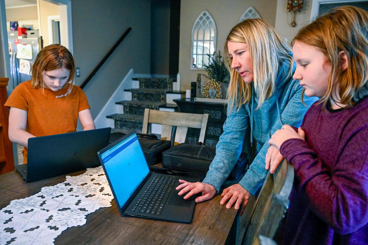 Christine Kraft talks with her daughters, Caydence, 11, left, and Corra Kraft, 9, as they log on to their school website at their Northland home. Kraft is a member of the Northland Parent Association, an organization that says it is anti-mask, anti-critical race theory and opposes books in schools they deem to have pornographic content.