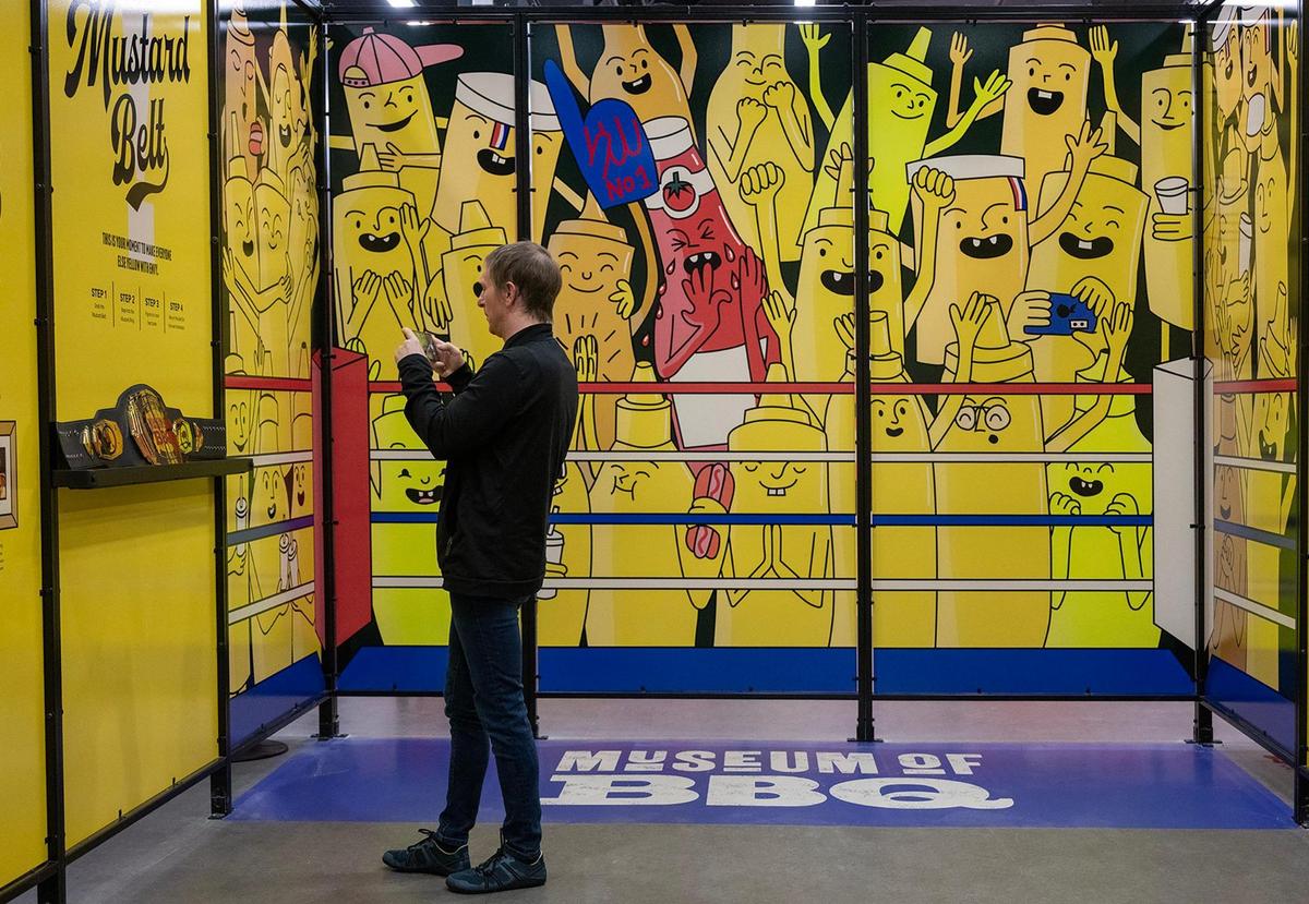 Jak Gerome of VisitKC, takes a photo of the exhibit that explains the Mustard Belt at the new Museum of BBQ. Major barbecue regions outside of Kansas City are represented at the museum.