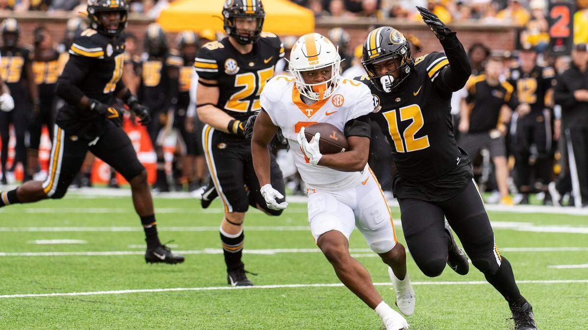 Tennessee running back Jabari Small, center, is chased by Missouri defensive back Shawn Robinson, right, and Blaze Alldredge, left, during the first half of an NCAA college football game Saturday, Oct. 2, 2021, in Columbia, Mo. (AP Photo/L.G. Patterson)