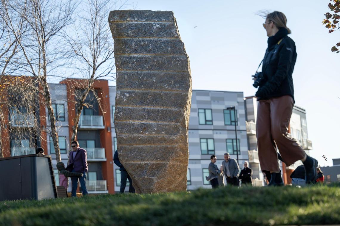Attendees of the park ribbon cutting check out the giant boulder the park is built around.
