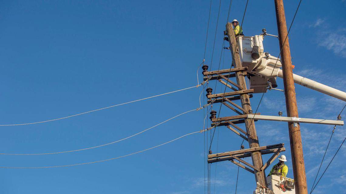 Evergy crew members repair a damaged electricity pole on West 25th Street in Kansas City on Thursday, Dec. 16, 2021. The damage comes a day after Kansas City experienced a severe thunderstorm.
