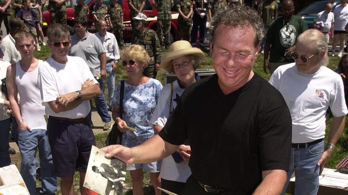 Art Fillmore looks through photographs included in a time capsule opened at the Vietnam Veterans Memorial in 2000.