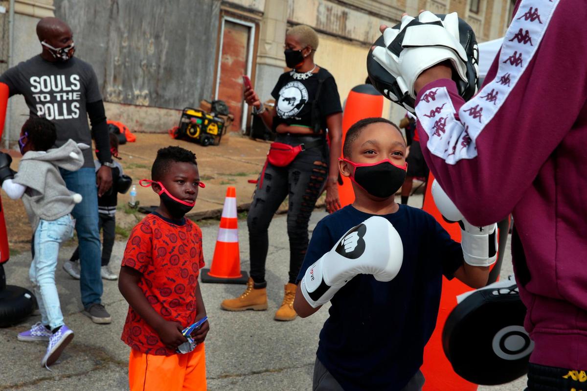 Josiah Orlando Taylor, 8, right, of Hanley Hills tries out boxing at the First MLK Street Festival in Wellston on Saturday, Oct. 10, 2020. Trauma surgeon Dr. LJ Punch and ‘The T’ anti-violence center calls the program ‘Punch Love’ to promote activity and exercise as an alternative to violence and is a partnership with the St. Louis Area Violence Prevention Commission. Each child that tried to box went home with their own boxing gloves.