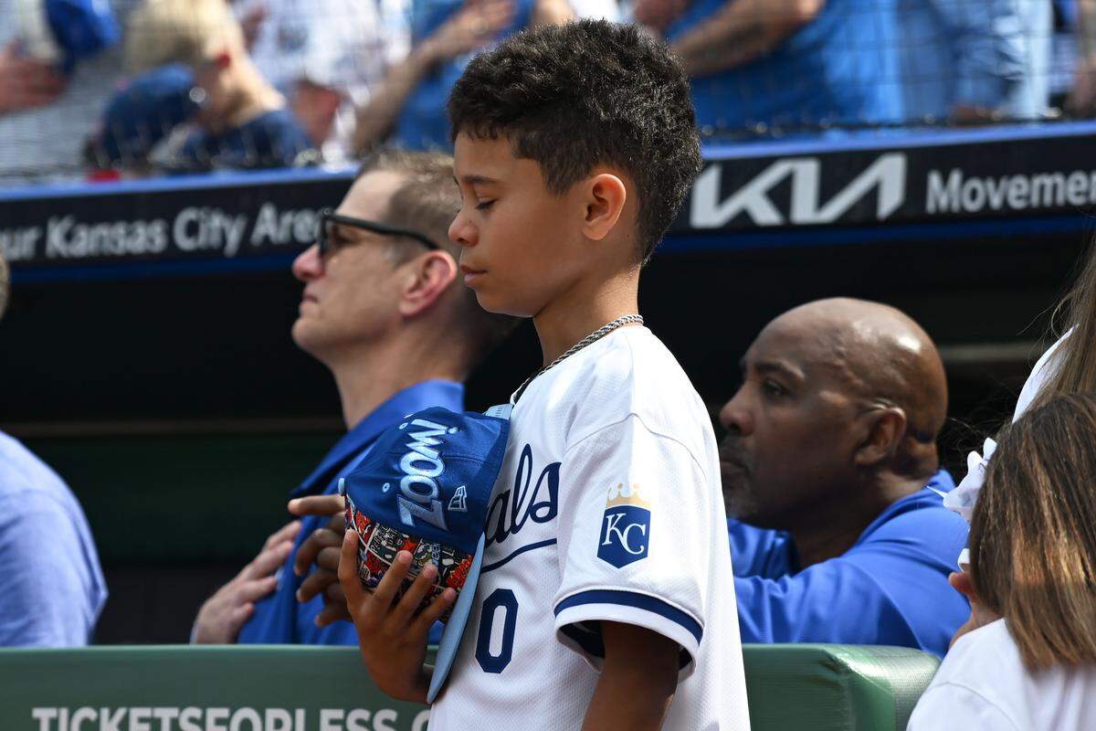 Zane Gore, son of Terrance Gore, closes his eyes during the national anthem before the home opener against the Minnesota Twins on Monday, March 30, 2026, in Kansas City.