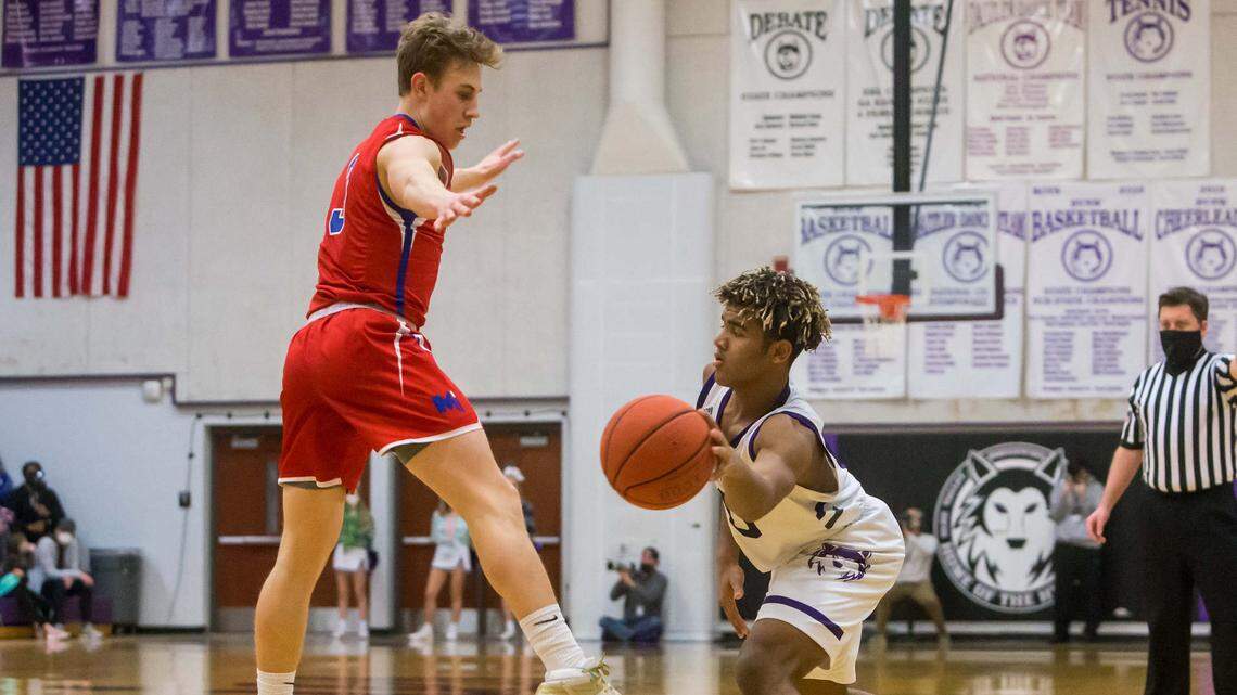 Blue Valley Northwest Sophomore Grant Stubblefield (0) attempts a pass around Bishop Miege Senior Harrison Braudis (3) during the game between Blue Valley Northwest and Bishop Miege at BVNW High School in Overland Park, Kansas. (Nick Tre. Smith/Special to the Star)